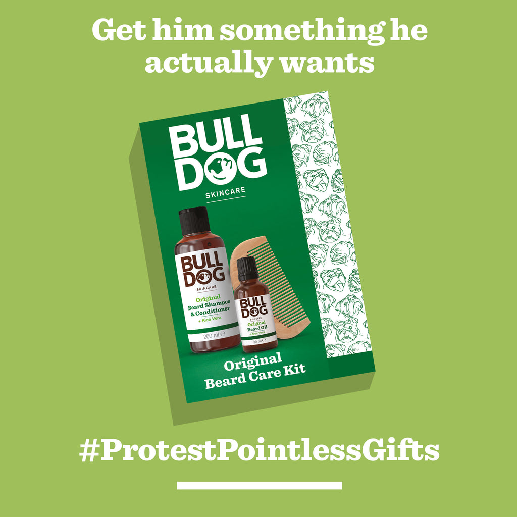 An Original Beard Care Kit with beard wash, oil, and a wooden comb is shown on a green background. Text above says Get him something he actually wants; below, #ProtestPointlessGifts. Perfect for effortless beard grooming by BLDG.