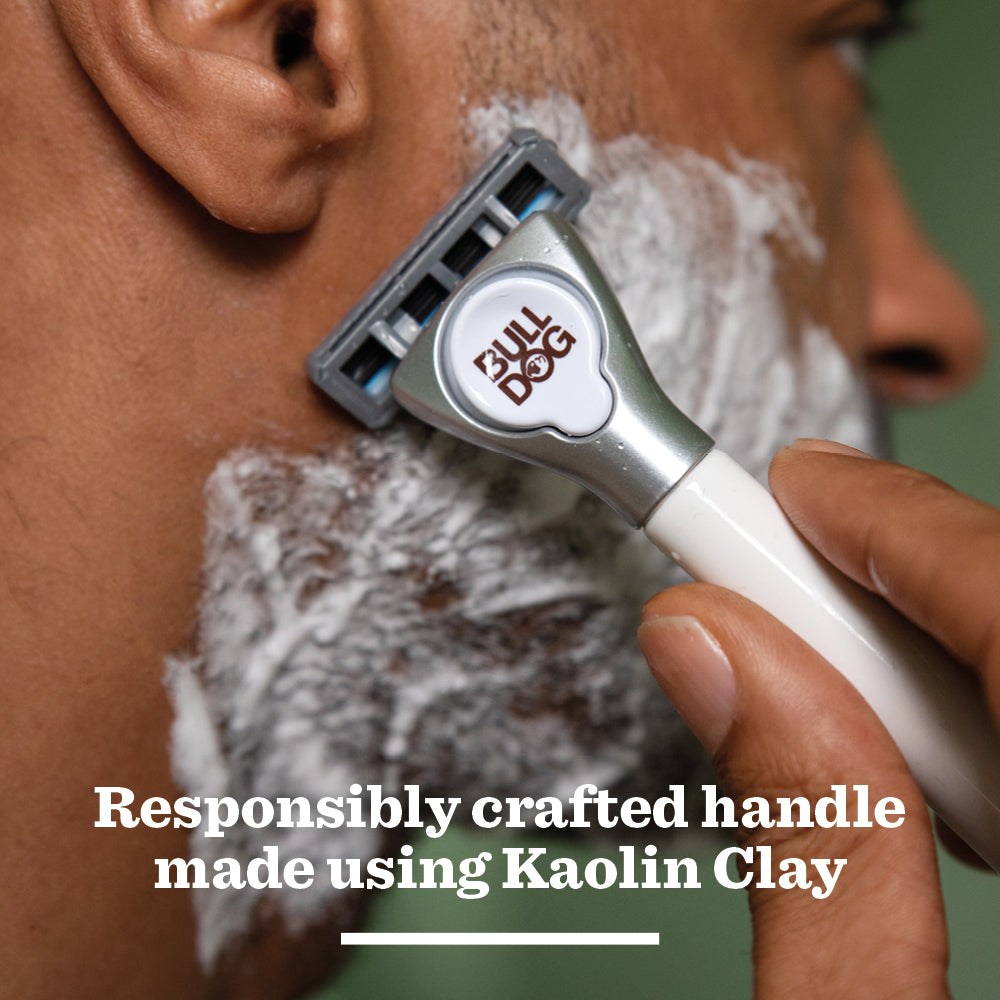 Close-up of a person shaving their foamy cheek with the Sensitive Ceramic Razor. Text reads: Responsibly crafted handle made using Kaolin Clay.