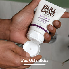 A person holds and squeezes a tube of Oil Control Moisturiser featuring natural origin ingredients. For Oily Skin is shown at the bottom, highlighting it as a top moisturiser for men with oily, acne-prone skin.