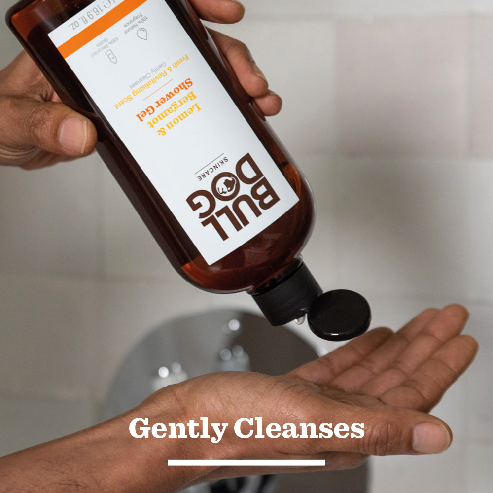 A person pours Lemon & Bergamot Shower Gel into their hand from a brown bottle, as the text Gently Cleanses appears at the bottom of the image.
